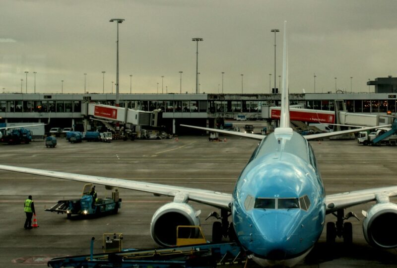 Vliegtuig met een passagiersbrug aan een gate op Schiphol.