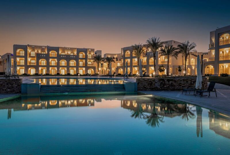 Hotel en buitenbad bij Sataya Resort Marsa Alam in Marsa Alam in avondlicht.